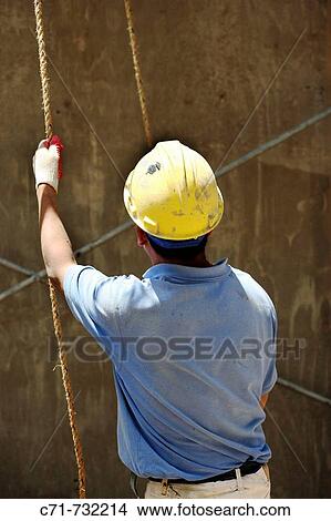Construction worker holding rope ready to hoist View Large Photo Image Picture - Construction worker holding rope ready to hoist. Fotosearch