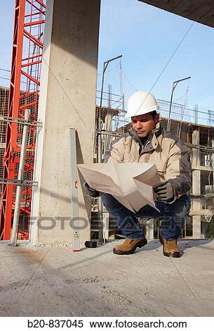 Construction worker looking at blueprints, personal protective equipment, housing construction, concrete skeleton View Large Photo Image Stock Photography - Construction worker looking at blueprints, personal protective equipment, housing construction, concrete skeleton. Fotosearch