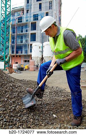 Stock Photo - Construction worker shoveling, hand tools for construction, Housing Construction, Basque Country, Spain. Fotosearch