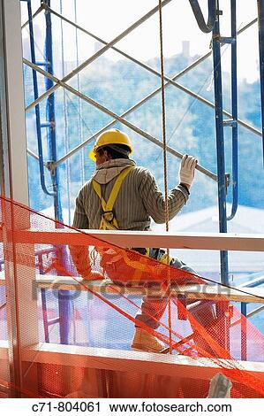Construction worker sitting on scaffolding View Large Photo Image Stock Image - Construction worker sitting on scaffolding. Fotosearch