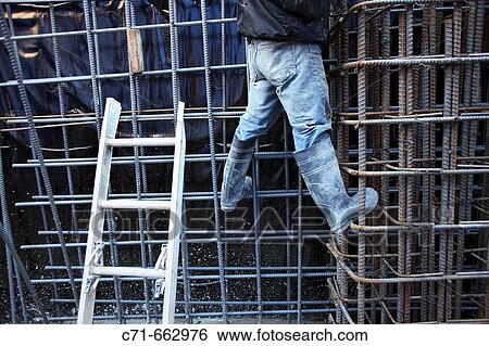 Construction worker standing on wall of steel rebar View Large Photo Image Stock Photograph - Construction worker standing on wall of steel rebar. Fotosearch