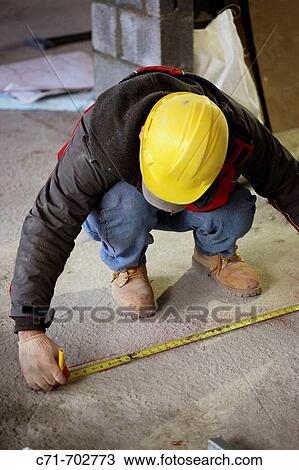 Construction worker taking marking measurement on floor View Large Photo Image Stock Image - Construction worker taking marking measurement on floor. Fotosearch
