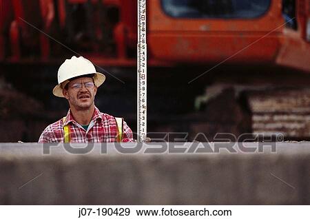 Construction worker with measuring staff. Texas. USA View Large Photo Image Stock Photo - Construction worker with measuring staff. Texas. USA. Fotosearch