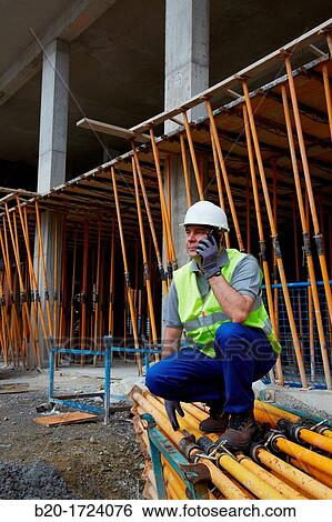 Stock Photograph - Construction worker with safety boots equipped, Horizontal formwork props, Building, Basque Country, Spain. Fotosearch