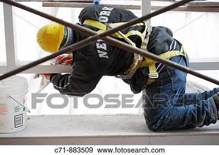 Construction worker with safety harness belt cleaning View Large Photo Image Stock Photo - Construction worker with safety harness belt cleaning. Fotosearch