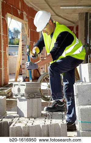 Stock Image - Construction worker with sledgehammer and chisel, Building hand tool, Donostia, San Sebastian, Gipuzkoa, Basque Country, Spain. Fotosearch