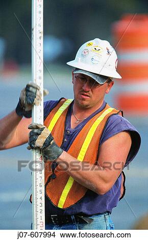 Picture - Construction worker with survey staff. Texas. USA. Fotosearch
