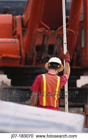 Stock Image - Construction worker with survey staff. Texas. USA. Fotosearch