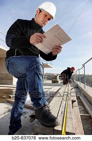Construction workers measuring, personal protective equipment, housing construction View Large Photo Image Stock Photo - Construction workers measuring, personal protective equipment, housing construction. Fotosearch
