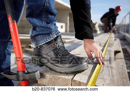 Construction workers measuring, personal protective equipment, housing construction View Large Photo Image Stock Photograph - Construction workers measuring, personal protective equipment, housing construction. Fotosearch