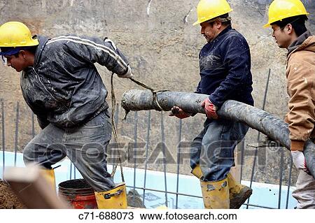 Construction workers moving concrete pumper hose View Large Photo Image Stock Image - Construction workers moving concrete pumper hose. Fotosearch