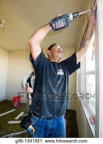 Construction workers repair a foreclosed home that was vandalized in Los Angeles, California, United States Black Shirt: Marco Moreno / White Pants: Antonio Perez / Blue Jeans: Fernando Perez View Large Photo Image Stock Image - Construction workers repair a foreclosed home that was vandalized in Los Angeles, California, United States Black Shirt: Marco Moreno / White Pants: Antonio Perez / Blue Jeans: Fernando Perez. Fotosearch