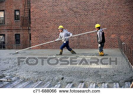 Construction workers smoothing concrete with long float View Large Photo Image Stock Photograph - Construction workers smoothing concrete with long float. Fotosearch