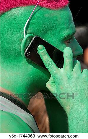 contemporary lifestyle, man's face painted in green colour, hair painted in red, man talking by mobile phone, taken during Lake Parade in Geneva, Switzerland View Large Photo Image Stock Image - contemporary lifestyle, man's face painted in green colour, hair painted in red, man talking by mobile phone, taken during Lake Parade in Geneva, Switzerland. Fotosearch
