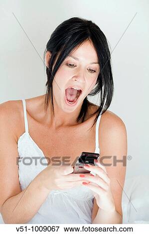 Stock Photo - Content woman reciving a text message. Fotosearch