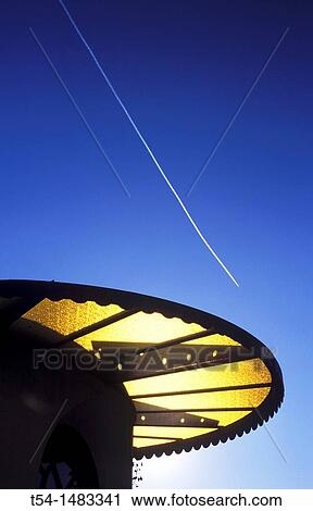 Stock Image - Contrail of an aircraft above the low sun of southern Italy. Fotosearch