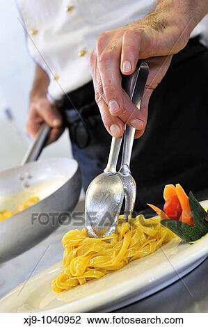Stock Image - Cook who prepares noodles. Fotosearch