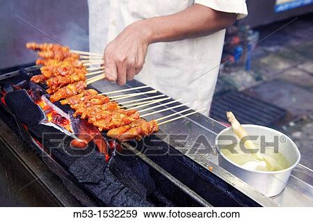 Cooking chicken skewers on a charcoal grill Kuala lumpur Malaysia View Large Photo Image Stock Photo - Cooking chicken skewers on a charcoal grill Kuala lumpur Malaysia. Fotosearch