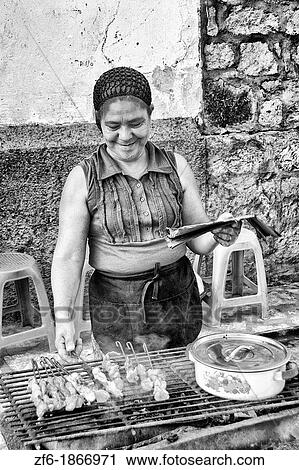 Stock Image - Cooking with local woman on grill for sale in Copan Ruinas Honduras downtown city action. Fotosearch