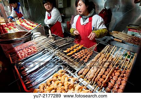 Cooks in small restaurant serving food on skewers for exemple fried octopuses at Wangfujing Snack Street in Dongcheng District, Beijing, China. View Large Photo Image Stock Photo - Cooks in small restaurant serving food on skewers for exemple fried octopuses at Wangfujing Snack Street in Dongcheng District, Beijing, China.. Fotosearch