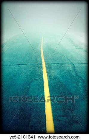 Stock Image - Country road in fog.. Fotosearch