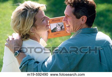couple admiring a photo of their pet View Large Photo Image Stock Image - couple admiring a photo of their pet. Fotosearch