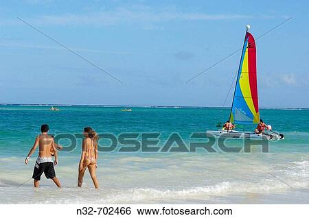 Stock Photograph - Couple and Catamaran at Maroma beach. Caribe. Quintana Roo state. Mayan Riviera. Yucatan Peninsula. Mexico. Fotosearch