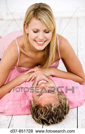Couple at home joking happy on the floor View Large Photo Image Stock Photo - Couple at home joking happy on the floor. Fotosearch