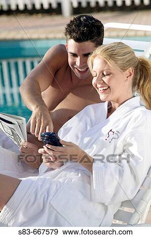 Couple at pool using a blackberry or PDA phone View Large Photo Image Stock Photo - Couple at pool using a blackberry or PDA phone. Fotosearch