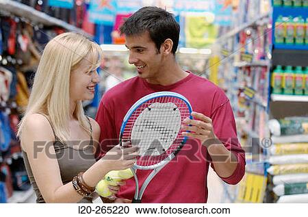 Stock Image - Couple at the sports section of a shopping center. Fotosearch