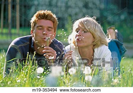 Picture - Couple blowing dandelions. Fotosearch