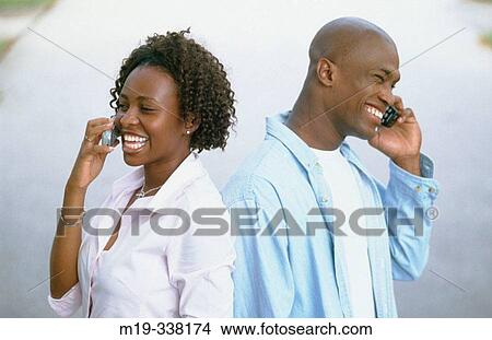 Picture - couple both on cellulars. Fotosearch