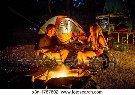 Couple by campsite fire with tents Sebago Lake Maine USA View Large Photo Image Stock Image - Couple by campsite fire with tents Sebago Lake Maine USA. Fotosearch