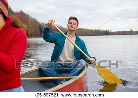 Couple canoeing on lake in autumn View Large Photo Image Stock Image - Couple canoeing on lake in autumn. Fotosearch