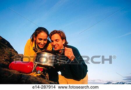Picture - Couple cooking meal on stove. Chugach State Park. Southcentral Alaska. Fotosearch