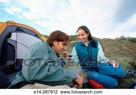 Stock Image - Couple cooking meal on stove. Chugach State Park. Southcentral Alaska. Fotosearch