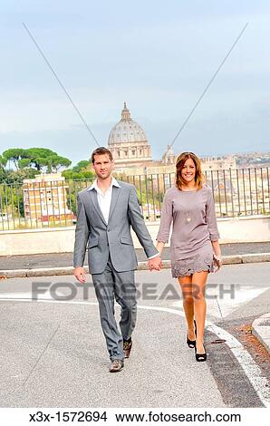 Couple crossing the street in front of Saint Peter's dome in Rome Italy View Large Photo Image Picture - Couple crossing the street in front of Saint Peter's dome in Rome Italy. Fotosearch