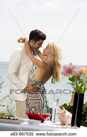 Stock Photography - Couple dining at the beach about to kiss. Fotosearch