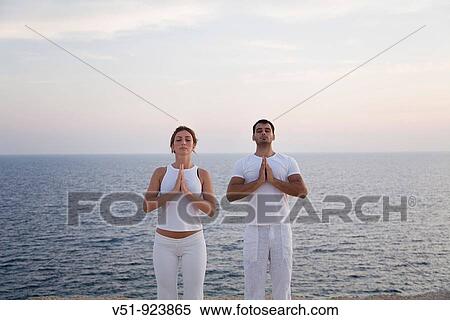 Couple doing yoga by the sea View Large Photo Image Stock Photography - Couple doing yoga by the sea. Fotosearch