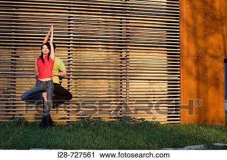 Couple doing yoga in the park View Large Photo Image Stock Image - Couple doing yoga in the park. Fotosearch
