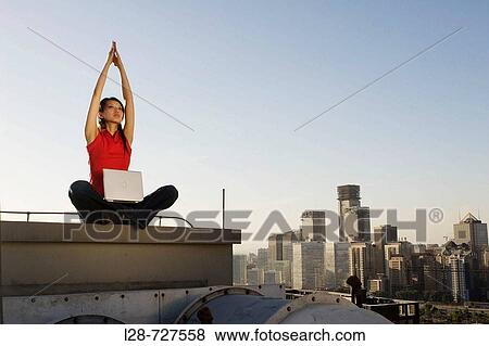 Couple doing Yoga with urban background View Large Photo Image Stock Photo - Couple doing Yoga with urban background. Fotosearch