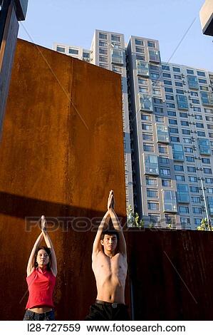 Couple doing Yoga with urban background View Large Photo Image Stock Photo - Couple doing Yoga with urban background. Fotosearch