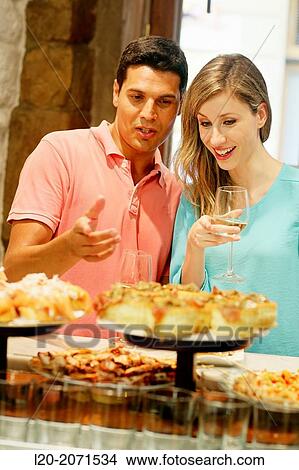 Couple drinking wine and eating tapas. Pintxos. Bar txondorra. Parte Vieja. Old town. San Sebastian. Donostia. Gipuzkoa. Basque Country. Spain. View Large Photo Image Picture - Couple drinking wine and eating tapas. Pintxos. Bar txondorra. Parte Vieja. Old town. San Sebastian. Donostia. Gipuzkoa. Basque Country. Spain.. Fotosearch