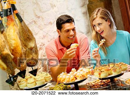 Couple drinking wine and eating tapas. Pintxos. Bar txondorra. Parte Vieja. Old town. San Sebastian. Donostia. Gipuzkoa. Basque Country. Spain. View Large Photo Image Stock Image - Couple drinking wine and eating tapas. Pintxos. Bar txondorra. Parte Vieja. Old town. San Sebastian. Donostia. Gipuzkoa. Basque Country. Spain.. Fotosearch