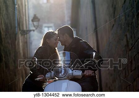 Couple embracing and leaning on a motor scooter View Large Photo Image Stock Image - Couple embracing and leaning on a motor scooter. Fotosearch