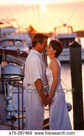 Stock Photo - couple embracing at the marina. Fotosearch