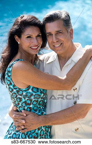 Couple embracing each other by the pool View Large Photo Image Stock Image - Couple embracing each other by the pool. Fotosearch