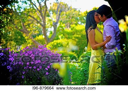 couple embracing / kissing in private garden setting View Large Photo Image Picture - couple embracing / kissing in private garden setting. Fotosearch