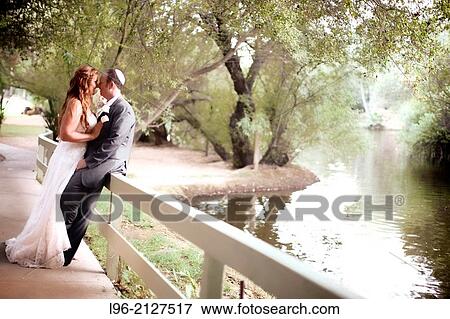 couple embracing, taking a moment to enjoy the moment and the beautiful lake scenery View Large Photo Image Stock Photo - couple embracing, taking a moment to enjoy the moment and the beautiful lake scenery. Fotosearch