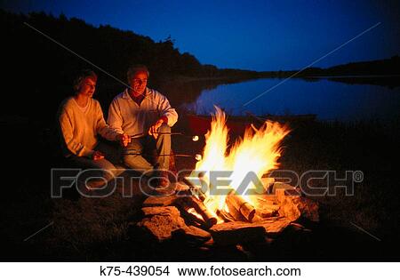 Couple enjoying campfire View Large Photo Image Picture - Couple enjoying campfire. Fotosearch